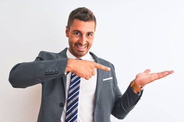 Takım elbiseli ve kravatlı genç yakışıklı iş adamı kameraya hayret ediyor ve gülümsüyor..