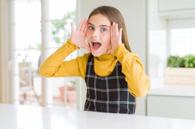 Evde rahat sarı kazak giyen genç güzel sarışın çocuk kız neşeli oyun Peek elleri ile yüz gösteren bir Boo gülümsüyor. Sürpriz ve çıkıldı