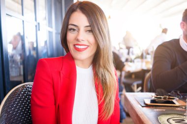 Güzel genç kadın restoranda oturan neşeli gülümseyen 