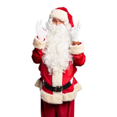 Orta yaşlı yakışıklı adam, Noel Baba kostümü ve sakal takmış rahatlamış ve gözleri kapalı, parmaklarıyla meditasyon hareketi yaparken gülümsüyor. Yoga konsepti.