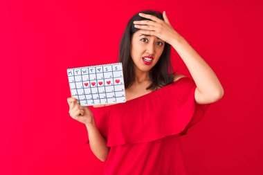 Genç, güzel Çinli bir kadın, izole edilmiş kırmızı arka planda nöbet tutuyor. Elleri başının üstünde, utanç ve şaşkınlık dolu, sinirli ve hayal kırıklığına uğramış bir halde. Hata için korku ve üzüntü.