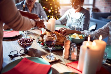 Aile ve arkadaşlar Noel arifesini geleneksel yemek ve dekorasyonla evde yemek yiyip akşam yemeği için hindi hazırlıyorlar.