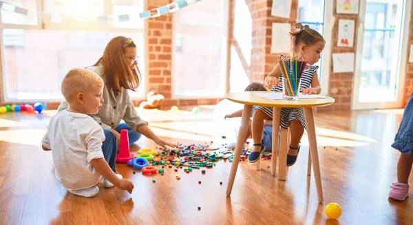 Vacker Lärare Och Grupp Småbarn Leker Runt Massor Leksaker Dagis — Stockfoto