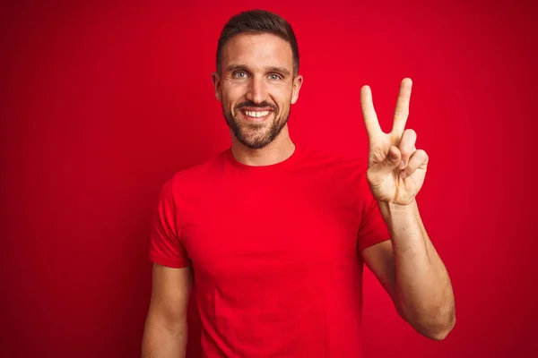 Mladý Pohledný Muž Neformálním Tričku Nad Červeným Izolovaným Pozadím Usmívající — Stock fotografie