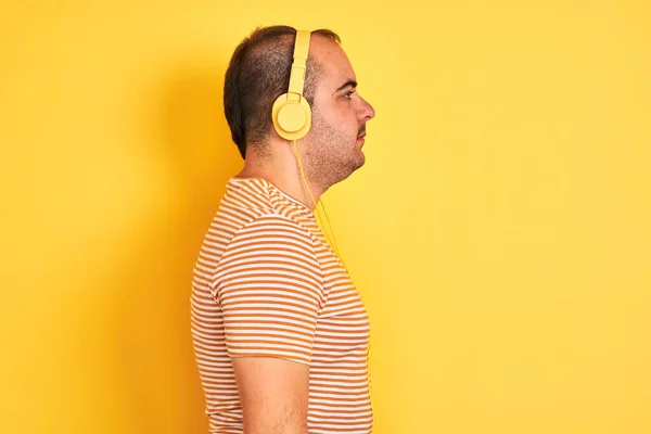 Joven Escuchando Música Usando Auriculares Parados Sobre Fondo Amarillo Aislado —  Fotos de Stock