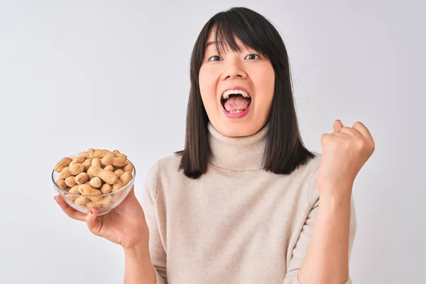 Ung Vacker Kinesisk Kvinna Håller Skål Med Jordnötter Över Isolerade — Stockfoto