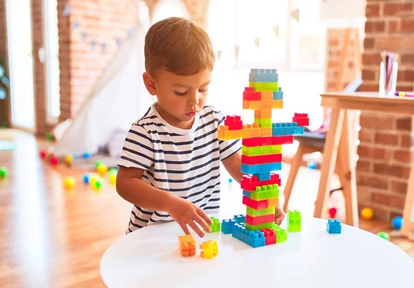 Güzel çocuk anaokulunda inşaat bloklarıyla oynuyor.