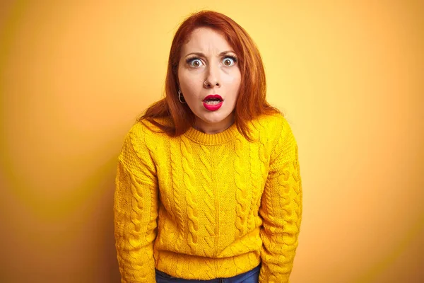 美丽的红头发女人 穿着冬季毛衣 站在孤立的黄色背景上 惊讶的表情 兴奋的脸 — 图库照片