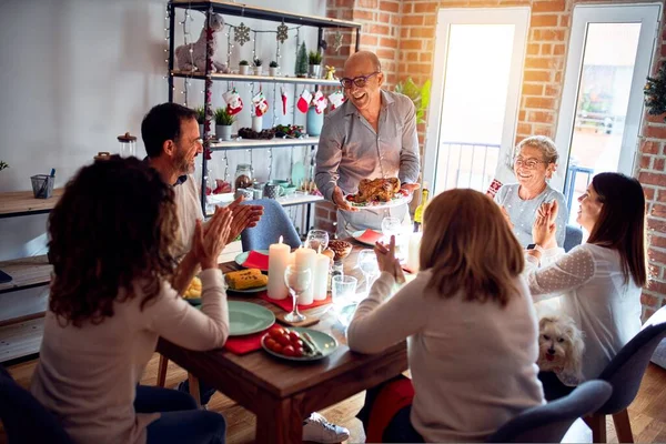 Family and friends dining at home celebrating christmas eve with traditional food and decoration, showing proud turkey cooking