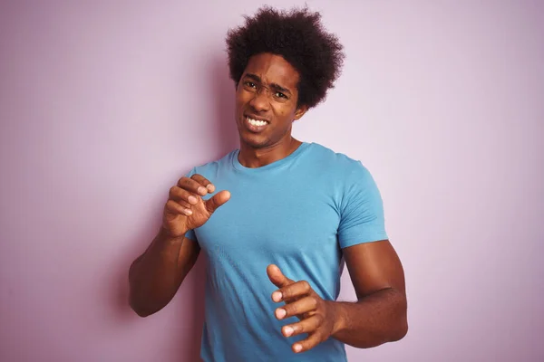 アフリカ系アメリカ人の男性は青いTシャツを着て孤立したピンクの背景に立っているアフロの髪は嫌悪反応のために嫌悪感の表情 不満と恐ろしい嫌な顔をしてうんざりしている 手を上げてどんなコンセプトでも — ストック写真