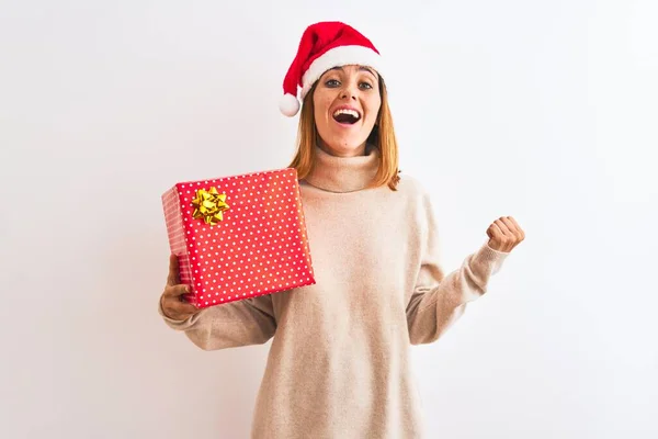 Schöne Rothaarige Frau Trägt Weihnachtsmütze Mit Geschenk Vor Isoliertem Hintergrund — Stockfoto