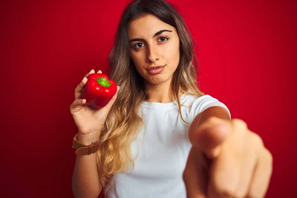 Joven Mujer Hermosa Sosteniendo Pimienta Sobre Fondo Rojo Aislado Señalando — Foto de Stock