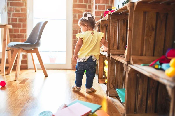 美しい幼児は幼稚園でたくさんのおもちゃの周りに立っています — ストック写真