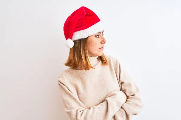 美しいです赤毛女性身に着けていますクリスマスの帽子を身に着けています隔離された背景上腕で横に見て確信と自信 — ストック写真