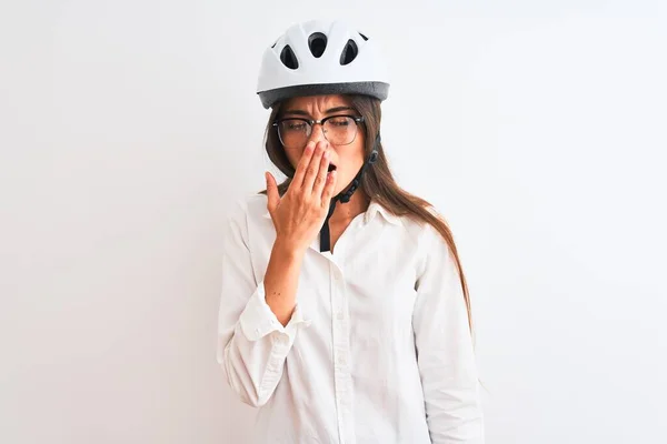 漂亮的女商人戴着眼镜 戴着自行车头盔 戴着白色的孤立背景 厌烦地打呵欠 双手捂着疲惫的嘴 烦躁不安和困倦 — 图库照片