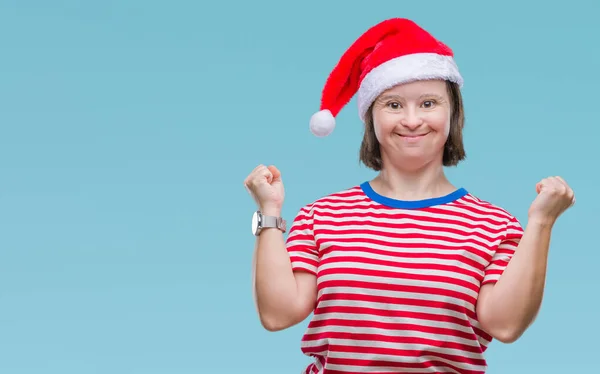 有唐氏综合症的年轻成年妇女戴着圣诞帽在与世隔绝的背景下庆祝成功 双臂张开眼睛 惊讶不已 赢家理念 — 图库照片