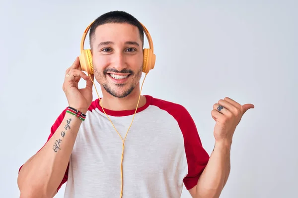 Young Handsome Man Wearing Headphones Isolated Background Pointing Showing Thumb — 스톡 사진