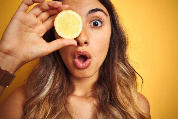 Jovem Bela Mulher Segurando Limão Olho Sobre Amarelo Isolado Fundo — Fotografia de Stock