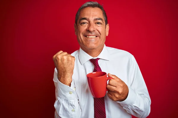 Przystojny Biznesmen Średnim Wieku Trzymając Filiżankę Kawy Nad Odizolowanym Czerwonym — Zdjęcie stockowe