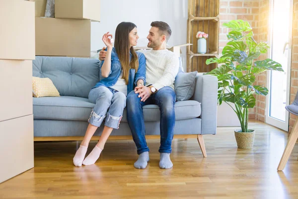 Junges Paar zieht in ein neues Zuhause, umarmt sich verliebt und zeigt Schlüssel — Stockfoto