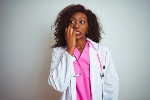 고립된 분홍색 청진기를 아프리카 미국인 의사는 손톱을 물면서 스트레스와 긴장을 — 스톡 사진