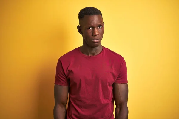 孤立した黄色の背景懐疑的で緊張した上に立って赤いTシャツを着た若いアフリカ系アメリカ人の男性は 問題のために動揺を眉をひそめています 負の人 — ストック写真