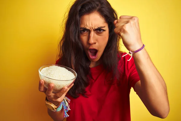 Young Beautiful Woman Holding Bowl Rice Isolated Yellow Background Annoyed — Stock Photo, Image