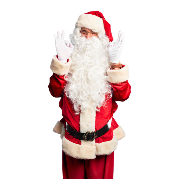 Middle age handsome man wearing Santa Claus costume and beard standing relaxed and smiling with eyes closed doing meditation gesture with fingers. Yoga concept.