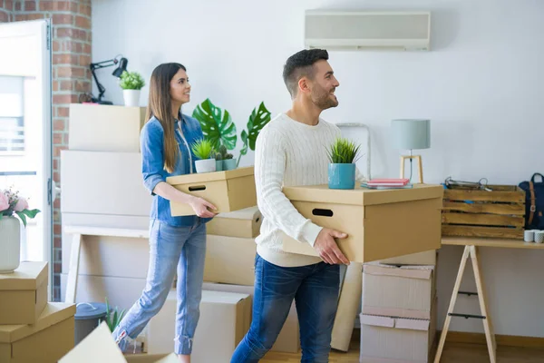 Jeune couple déménageant dans une nouvelle maison, souriant heureux tenant cardboa — Photo