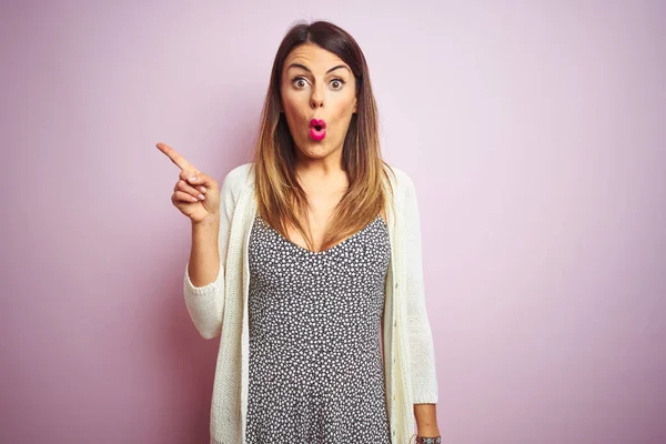 Giovane Bella Donna Piedi Sfondo Rosa Isolato Sorpreso Indicando Con — Foto Stock