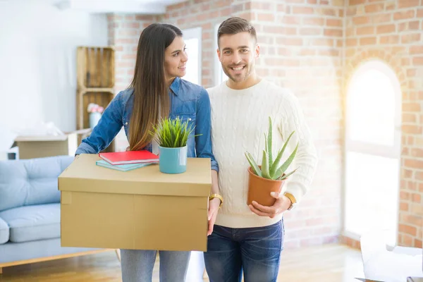 Belo jovem casal se mudando para uma nova casa, sorrindo feliz segurar — Fotografia de Stock