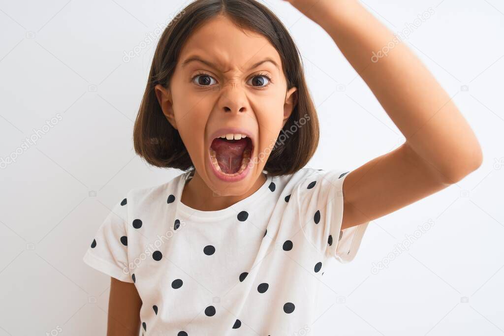 Young beautiful child girl wearing casual t-shirt standing over isolated white background annoyed and frustrated shouting with anger, crazy and yelling with raised hand, anger concept