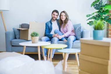 Genç çift içinde aşk sarılma oturma üzerinde the kanepe çok mutlu Moving için bir yeni ev
