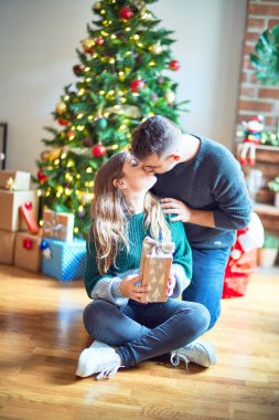 Mutlu ve kendinden emin gülümseyen genç bir çift. Erkek, hediyesiyle eve gelen bir kadına sürpriz yapar.