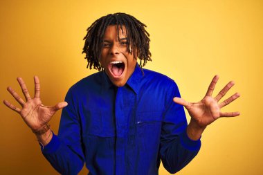 Sarı arka plan üzerinde mekanik üniforma giyen Afrikalı işçi çılgınca kutlama yapıyor ve kollarını kaldırıp heyecanla haykırarak başarıyı kutluyor. Kazanan konsept