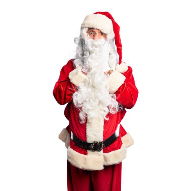 Orta yaşlı yakışıklı adam, Noel Baba kostümü ve sakal takıyor. Korkmuş ve şok olmuş duruyor. Şaşırmış ve şaşırmış bir halde.