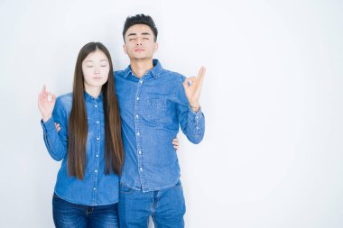 Beyaz izole arka plan üzerinde güzel genç Asya çift Relax ve gözleri ile gülümseyen meditasyon jest parmaklar ile kapalı. Yoga konsepti.