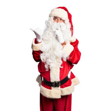 Orta yaşlı yakışıklı, Noel Baba kostümü ve sakallı bir adam sessiz olmak istiyor. Parmakları dudaklarında, elleri yanda. Sessizlik ve gizli konsept.