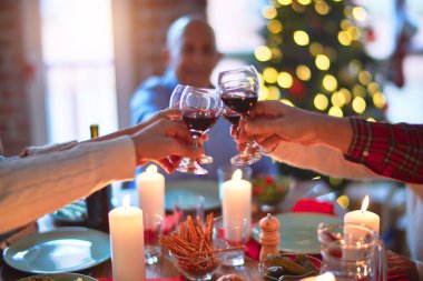 Mutlu ve kendinden emin gülümseyen güzel bir aile. Kızarmış hindi yemek ve evde Noel 'i kutlamak için bir bardak şarapla kadeh kaldırmak.