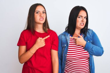 İzole edilmiş beyaz arka planda dikilen gündelik giysiler giyen genç ve güzel kadınlar endişeli ve endişeli ifadeler sergiliyorlar.