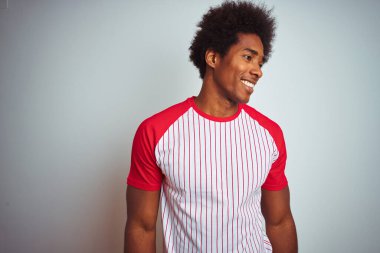 Afro saçlı, kırmızı çizgili tişörtlü, izole edilmiş beyaz arka planda, yüzünde gülümseme, doğal bir ifade olan Afro-Amerikan bir adam. Kendinden emin gülen.