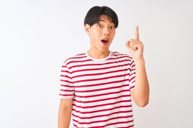 Genç Çinli adam rahat çizgili t-shirt izole beyaz arka plan üzerinde başarılı bir fikir ile parmak işaret üzerinde duran giyiyor. Çıktı ve mutlu. Bir numara.