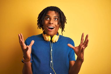 Sarı arka plan üzerinde kulaklık takan Afro-Amerikan bir adam. Kızgın, deli deli bağırıyor ve agresif bir ifadeyle ve kollarıyla bağırıyor. Hayal kırıklığı konsepti.