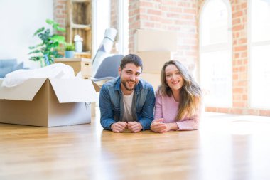 Yeni bir eve taşımak için etrafında karton kutular ile birlikte katta yatarken rahatlatıcı aşk genç güzel çift