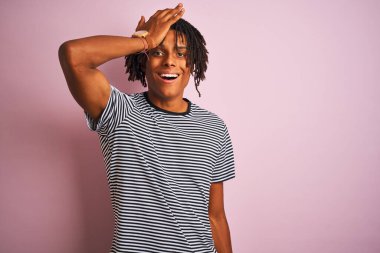 Rasta desenli tişörtlü Afro bir adam izole edilmiş pembe arka planda dikiliyor. Hatayla el ele tutuşup şaşırıyor. Hatayı hatırla. Unuttum, kötü hafıza konsepti.