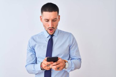 Genç ve yakışıklı bir iş adamı, geçmişinden izole edilmiş bir telefon kullanıyor. Şaşırmış bir yüzle korkmuş ve korku ifadesinden heyecanlanmış.