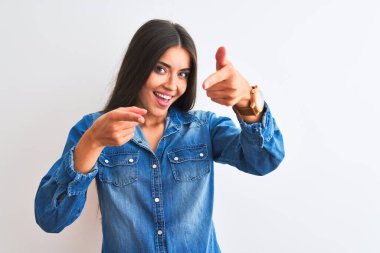 İzole edilmiş beyaz arka plan üzerinde dikilmiş, mutlu ve komik yüzlü genç ve güzel bir kadın. İyi enerji ve titreşimler.