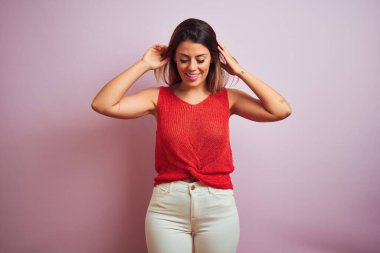 Turuncu t-shirt giyen ayakta genç güzel İspanyol kadın