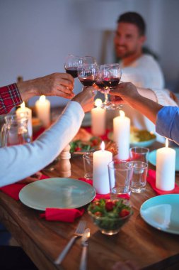 Mutlu ve kendinden emin gülümseyen güzel bir aile. Kızarmış hindi yemek ve evde Şükran Günü 'nü kutlamak için bir bardak şarapla kadeh kaldırmak.