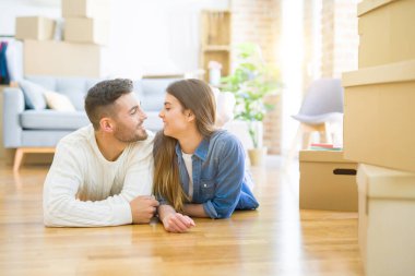 Yeni evin katında yatan genç güzel çift, gülümseyen 